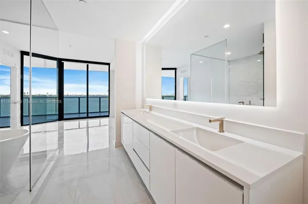 a large white kitchen with a large window