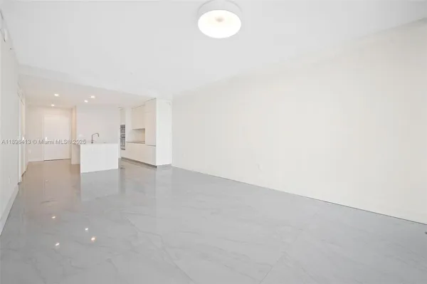 an empty room with a kitchen and a window