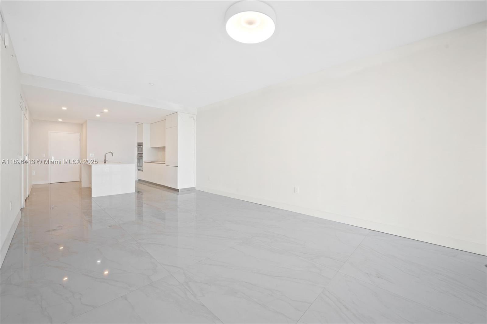 700 Northeast 24th Street, Unit 702 Miami, FL 33137 - Photo 6 of 55 an empty room with a kitchen and a window