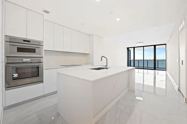a kitchen with a sink cabinets and stainless steel appliances