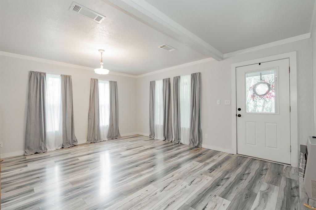 853 County Road 2215 Decatur, TX 76234 - Photo 33 of 39 Guest house living area featuring crown molding, light wood-style floors, plenty of natural light, beamed ceiling, and heating unit
