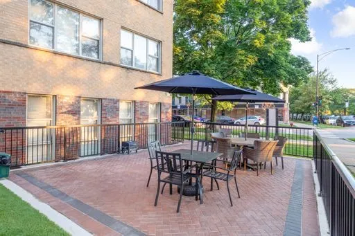 a view of a patio with a table and chairs under an umbrella