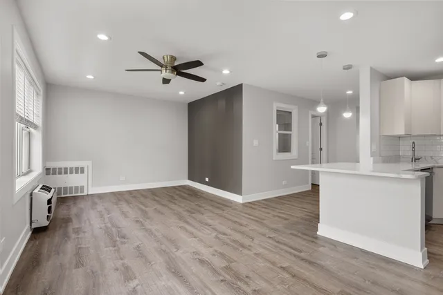 a view of kitchen with sink microwave and wooden floor