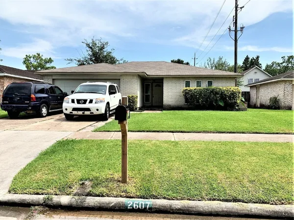 a front view of a house with a garden and parking
