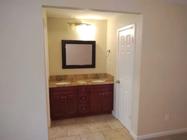 an empty room with mirror and a bathroom