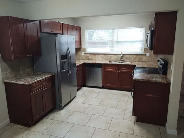 a kitchen with stainless steel appliances granite countertop a stove a refrigerator and a sink