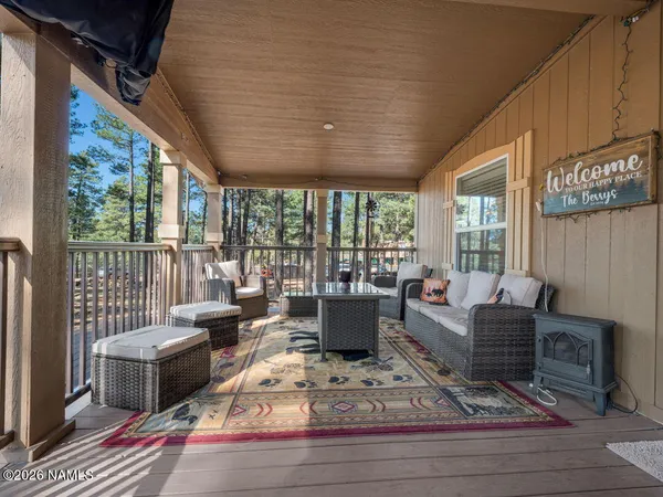 a living room with furniture large windows and wooden floor