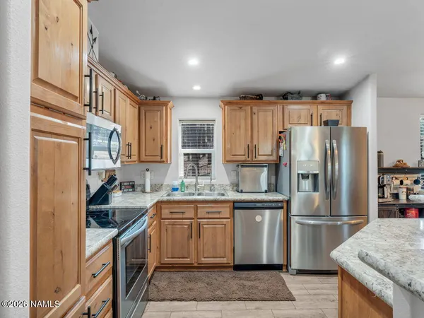 a kitchen with stainless steel appliances granite countertop a refrigerator a stove and a sink