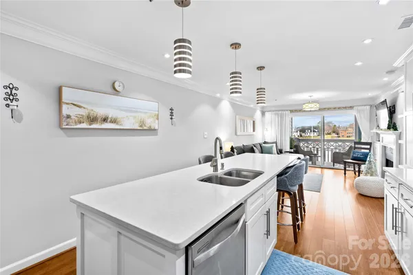 a view of a dining room and livingroom with furniture wooden floor a chandelier