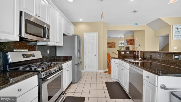 a kitchen with stainless steel appliances granite countertop a stove a refrigerator and a microwave