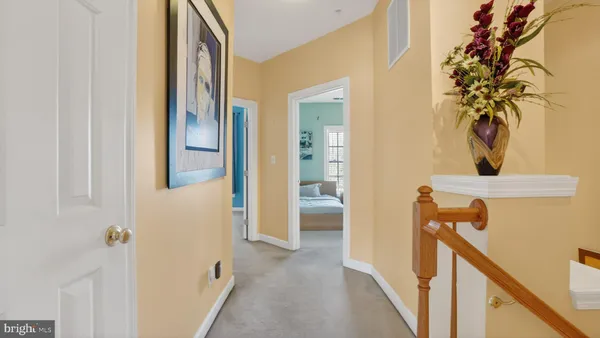 a bedroom with a bed a dresser and painting on the wall