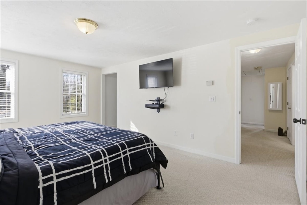 133 Grove Street Bellingham, MA 02019 - Photo 31 of 42 a bedroom with a bed and a flat screen tv