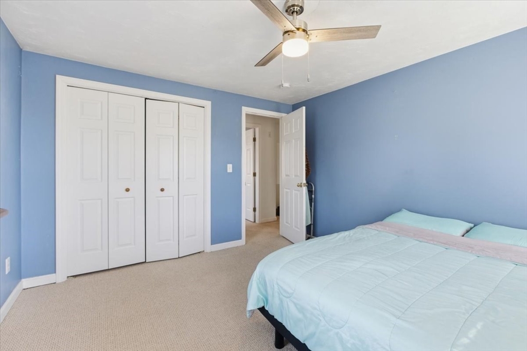 133 Grove Street Bellingham, MA 02019 - Photo 36 of 42 a bedroom with a large bed and a chandelier fan