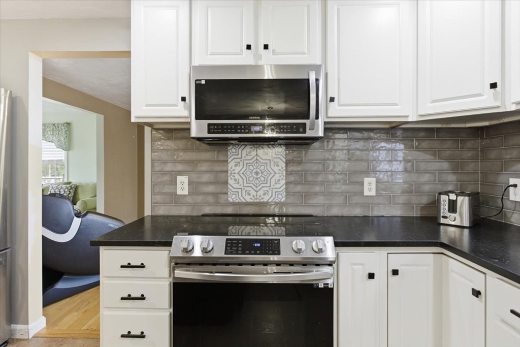 133 Grove Street Bellingham, MA 02019 - Photo 7 of 42 a kitchen with stainless steel appliances granite countertop a stove and a microwave