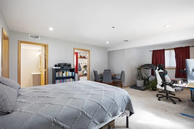 a bedroom with a bed a large window and furniture