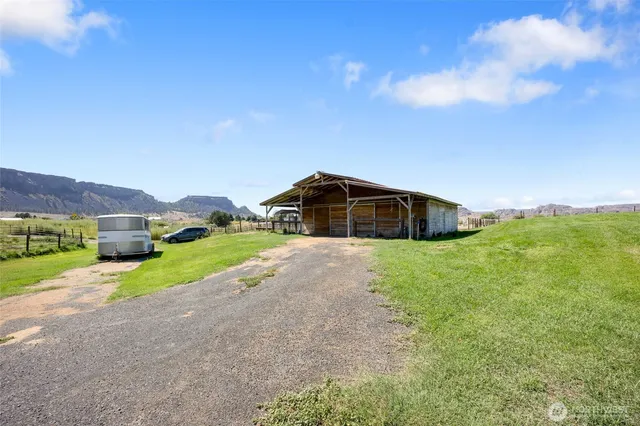 a view of a house with a yard and large trees