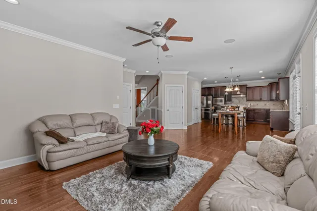 a kitchen with stainless steel appliances granite countertop a stove top oven a refrigerator a sink and a dining table with wooden floor