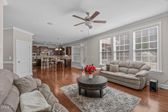 a kitchen with stainless steel appliances granite countertop a stove top oven a sink a dining table and chairs with wooden floor