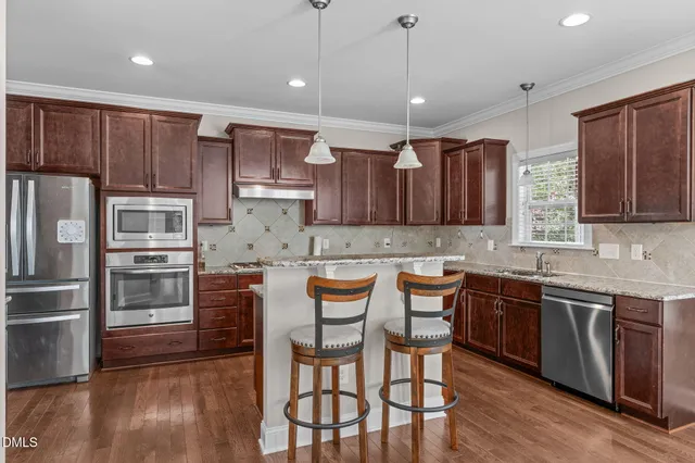 a kitchen with granite countertop a sink a stove and cabinets