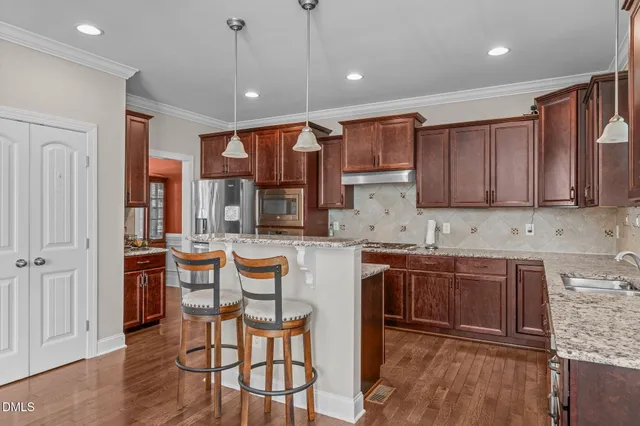a kitchen with stainless steel appliances granite countertop a stove a sink and a microwave
