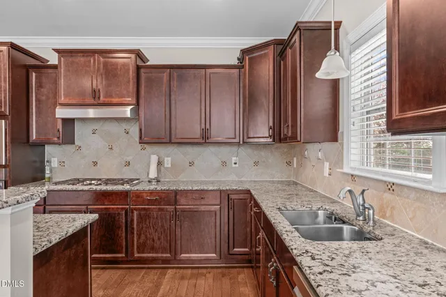 a kitchen with stainless steel appliances granite countertop a stove and a wooden floors