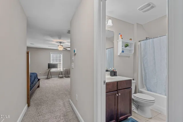 a bedroom with a bed and a lamp on dresser