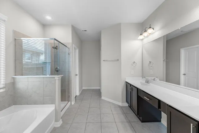 a bath room with a sink tub and a mirror