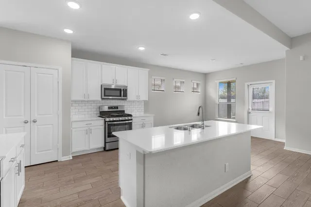 a kitchen with kitchen island a counter top space stainless steel appliances and a window