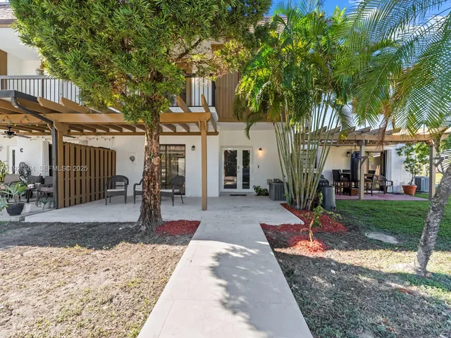 a view of a house with a yard and large tree