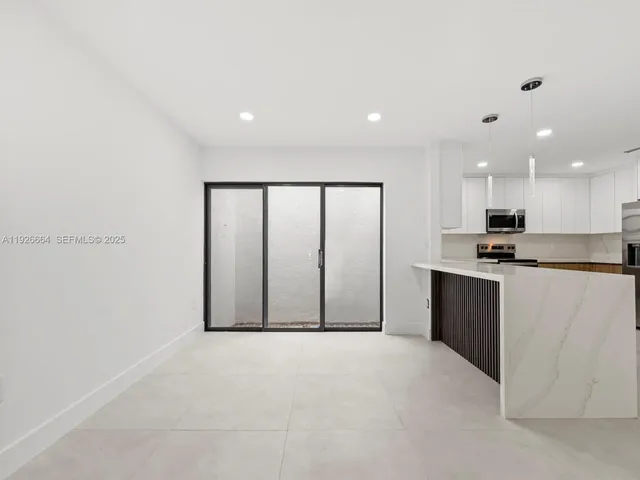 a view of an empty room with kitchen