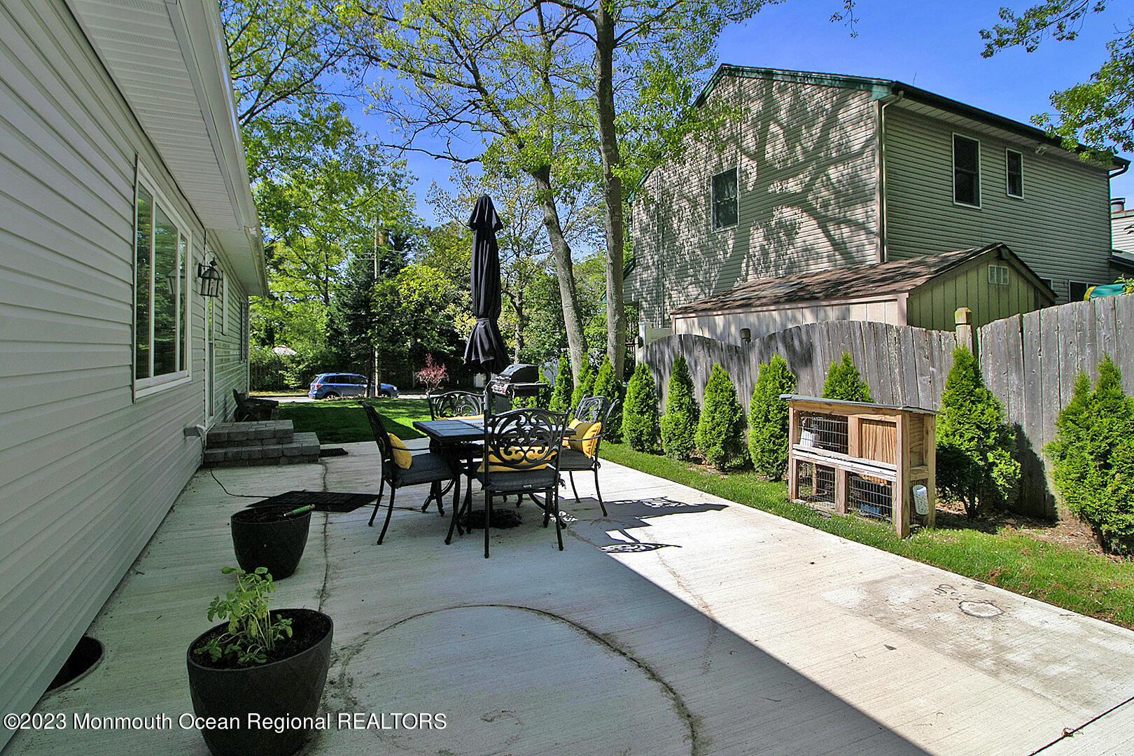 187 Topside Road Manahawkin, NJ 08050 - Photo 61 of 66 a view of a patio with table and chairs potted plants and a large tree