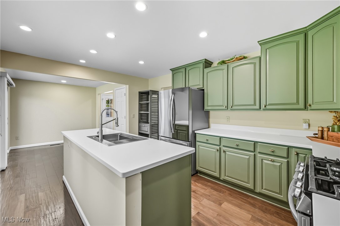 6264 Herbert Road Canfield, OH 44406 - Photo 9 of 47 Kitchen featuring green cabinetry, a kitchen island with sink, stainless steel appliances, recessed lighting, and dark wood-style flooring