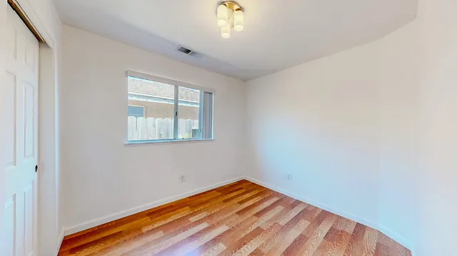 a view of an empty room with wooden floor
