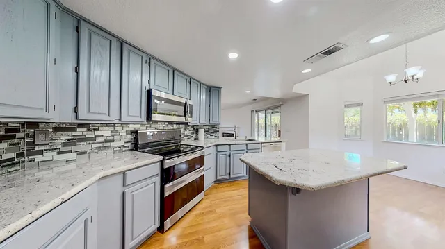 a kitchen with granite countertop stainless steel appliances and wooden cabinets