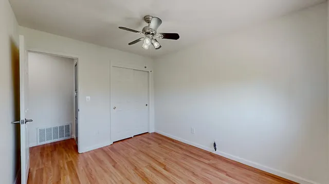 a bedroom with a bed and wooden floor
