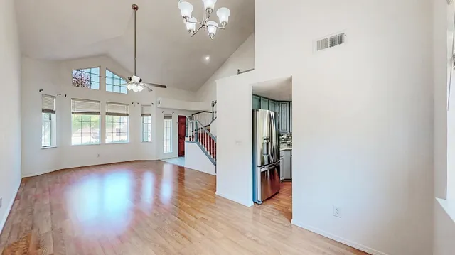 an empty room with wooden floor fireplace and windows