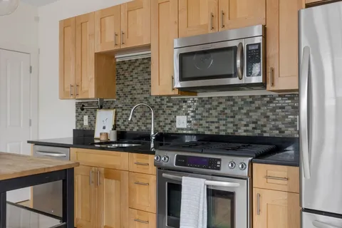a kitchen with stainless steel appliances granite countertop a stove and a microwave