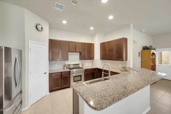 a kitchen with stainless steel appliances granite countertop a sink stove and refrigerator