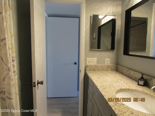a bathroom with a granite countertop sink and mirror