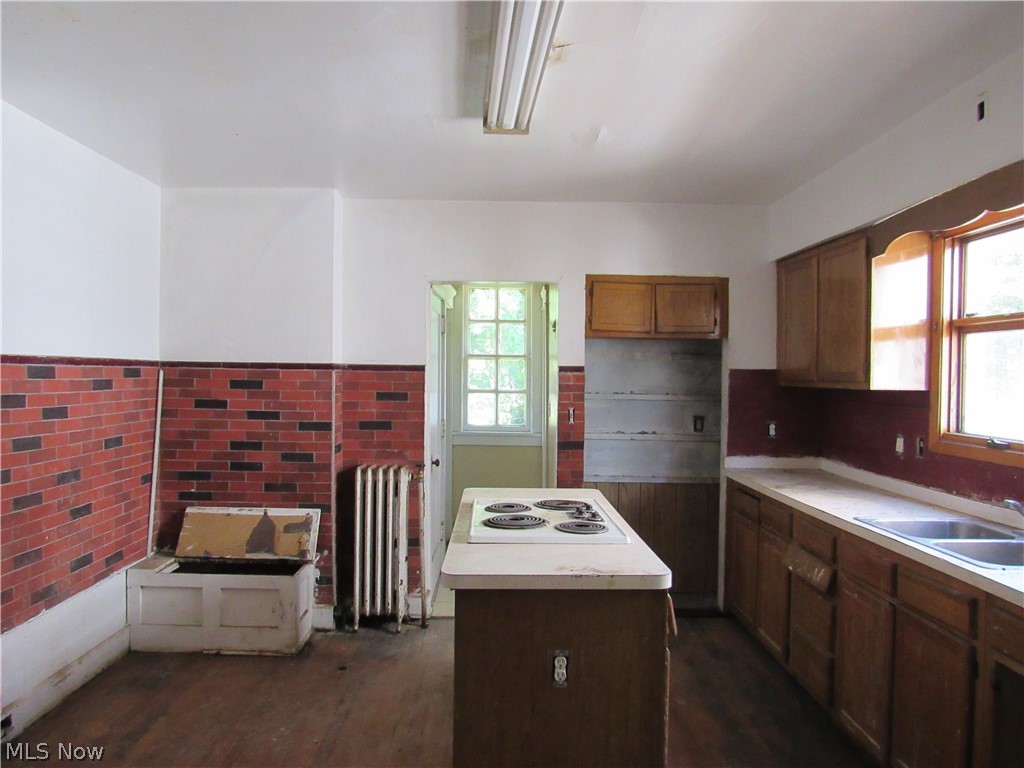 1726 Lee Road Cleveland Heights, OH 44118 - Photo 7 of 36 Kitchen space featuring an island with a built-in cooktop, ample cabinetry, dual basin sink, and a large window