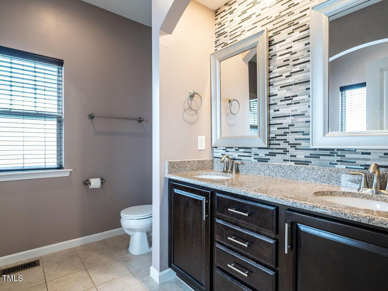 1316 Cornell Place Raleigh, NC 27607 - Photo 19 of 31 a bathroom with a granite countertop sink a toilet and a mirror