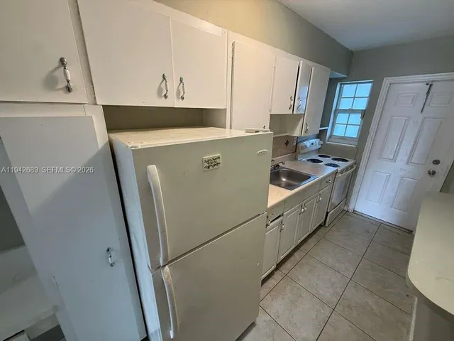 a kitchen with cabinets and white appliances