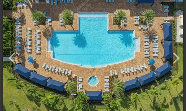 a view of a brick wall with a bench and potted plants