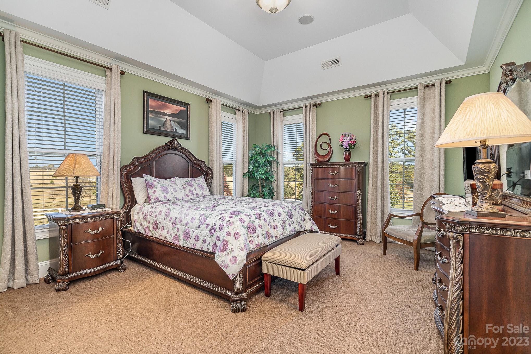 6224 Medlin Road Monroe, NC 28112 - Photo 8 of 21 a bedroom with a large bed and a chandelier