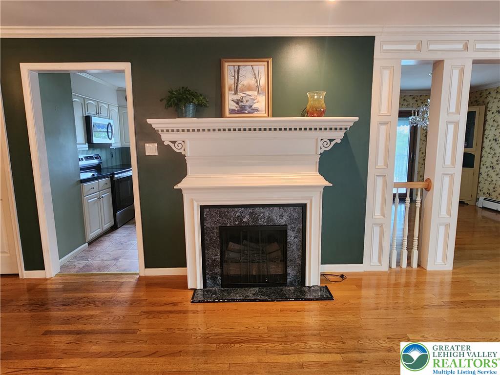 1480 Teels Road Pen Argyl, PA 18072 - Photo 8 of 18 Rich hardwood flooring complements the classic fireplace with its ornate white mantelpiece.