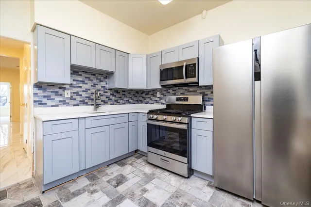 a kitchen with stainless steel appliances granite countertop a stove a refrigerator and a microwave