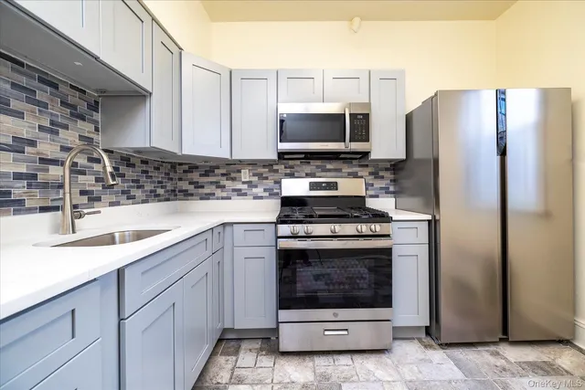 a kitchen with stainless steel appliances granite countertop a refrigerator stove and sink