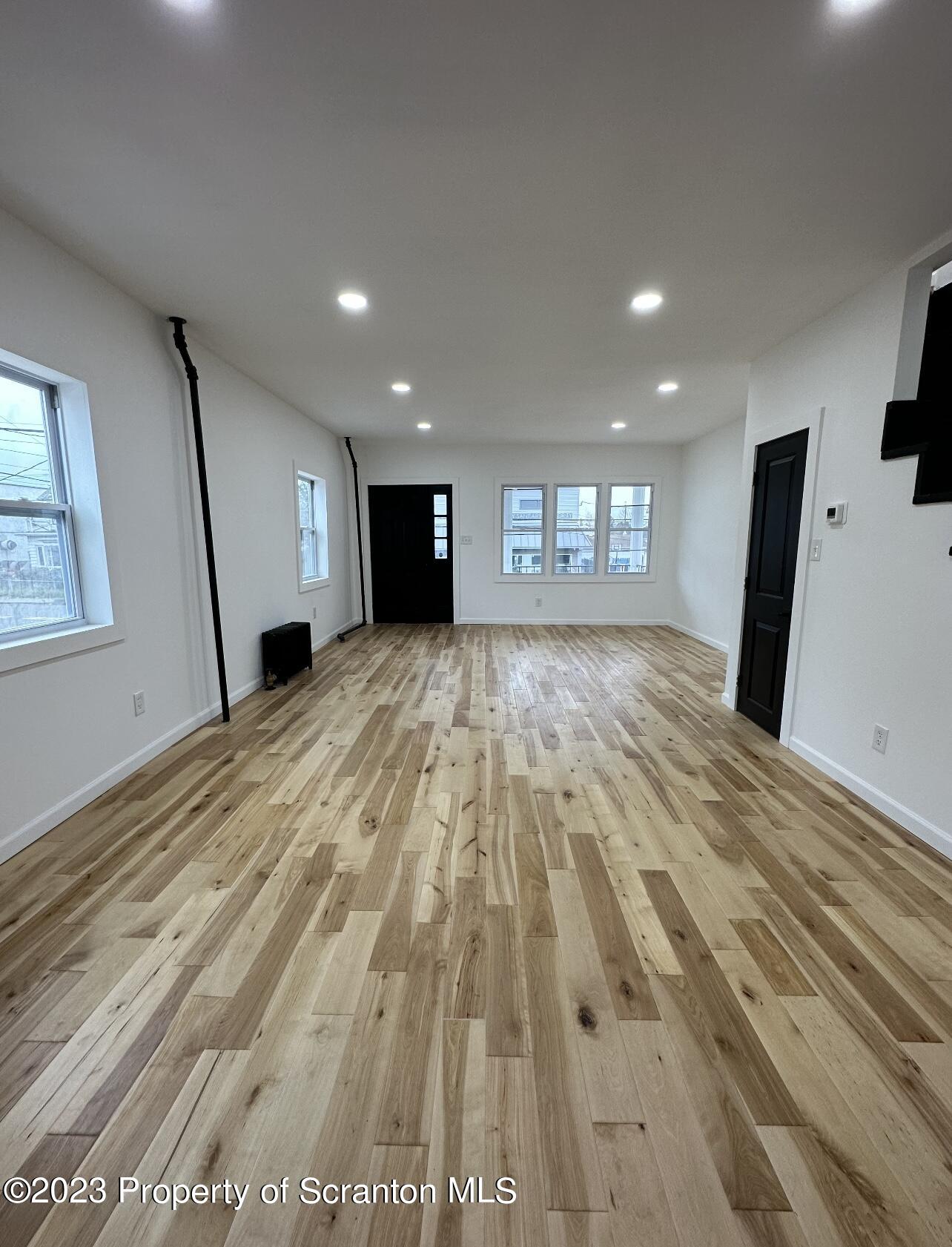 301 Oak Street Old Forge, PA 18518 - Photo 11 of 19 a view of an empty room with wooden floor and a window