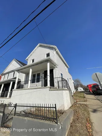 a view of a white house with a large space