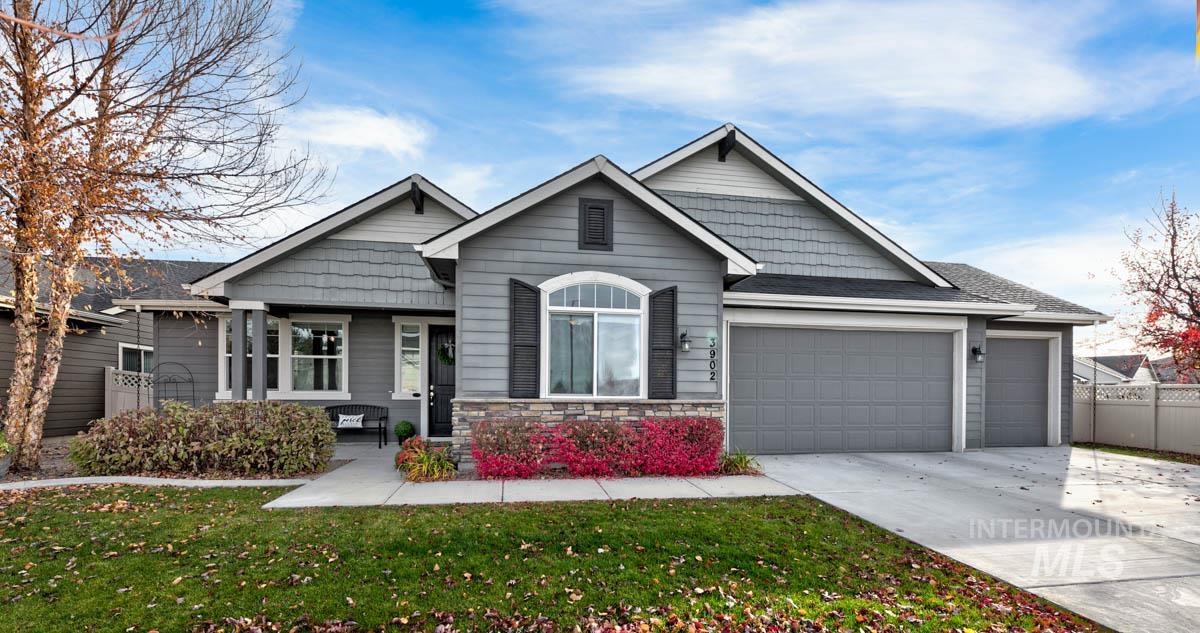 3902 North Rotaldo Avenue Meridian, ID 83646 - Photo 1 of 34 View of front of home with stone siding, a garage, driveway, and roof with shingles